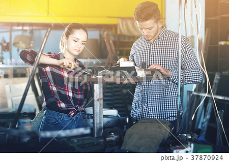Two young professional masters working in workshop Two young professional masters working in workshop 37870924