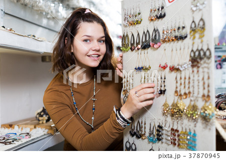 Young girl seller offering colored earrings 37870945