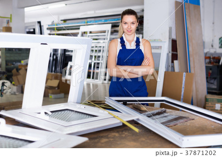 Confident girl assembler of plastic windows standing with arms crossed Confident girl assembler of plastic windows standing with arms crossed 37871202