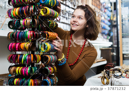 Girl seller offering colored bracelets Girl seller offering colored bracelets 37871232