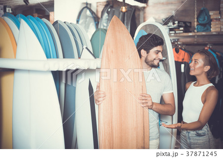 man and woman choosing surfboards man and woman choosing surfboards 37871245