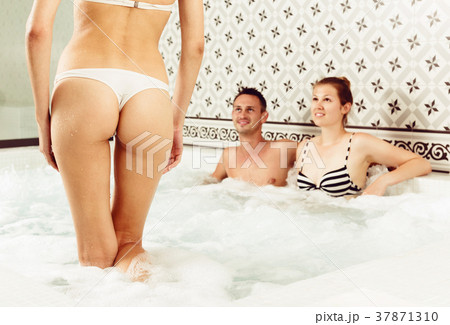People relaxing in jacuzzi 37871310