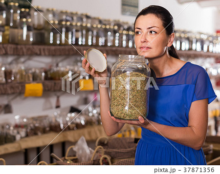 adult female take a smell natural dried herbs sold by weight in eco shop adult female take a smell natural dried herbs sold by weight in eco shop 37871356