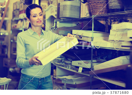 Woman standing with wooden box in decoration and furniture store Woman standing with wooden box in decoration and furniture store 37871680