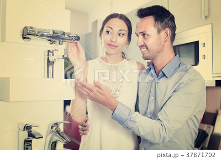 Smiling family choosing faucet for kitchen Smiling family choosing faucet for kitchen 37871702