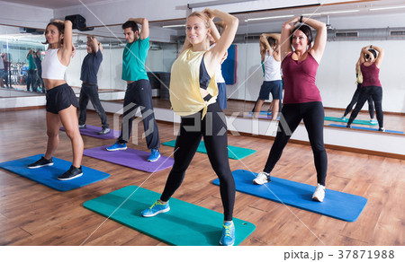 Happy people studying zumba elements in dancing hall 37871988