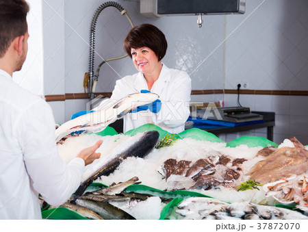 Customer choosing and buying fish 37872070