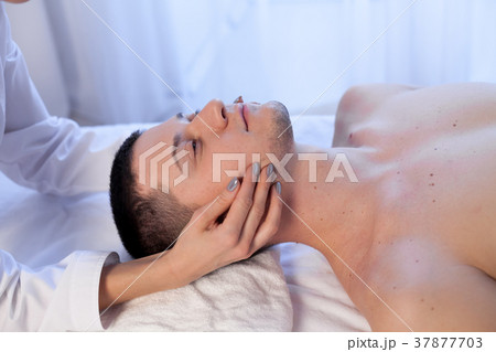 doctor cosmetologist doing facial massage men spa 37877703