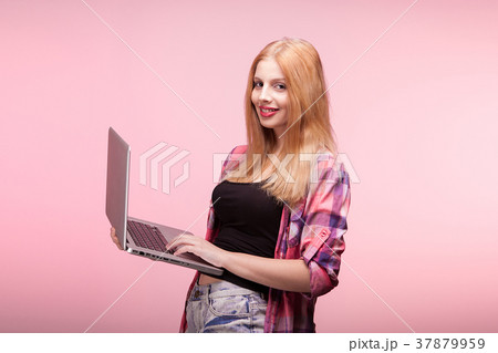 Girl smiling at the camera with a laptop in hands Girl smiling at the camera with a laptop in hands 37879959