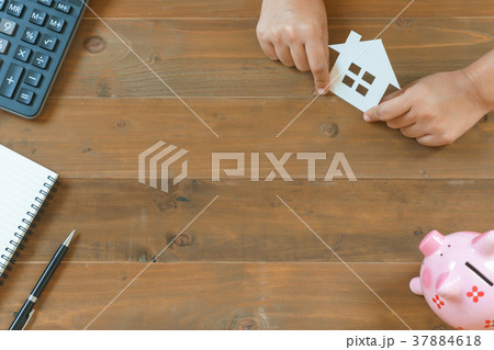 hands holding house paper with calculator 37884618