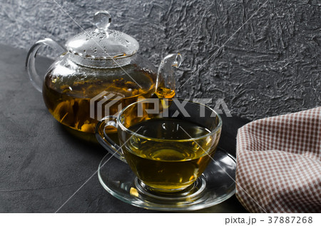 Cup of delicious herbal tea and glass teapot. Cup of delicious herbal tea and glass teapot. 37887268