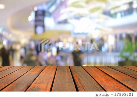 blur wood table on people walk in shopping centre blur wood table on people walk in shopping centre 37895501
