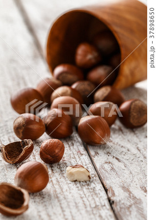 Hazelnut heap on wooden table, selective focus. 37898650
