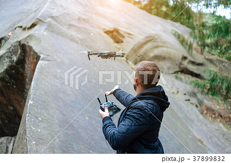 guy starts a quadrocopter in the forest 37899832