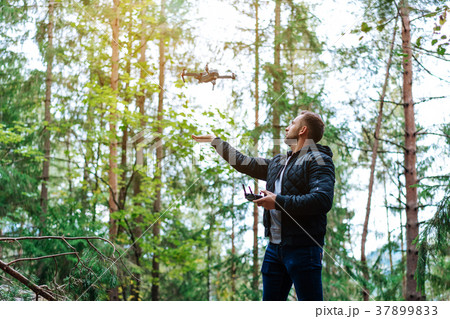 guy starts a quadrocopter in the forest guy starts a quadrocopter in the forest 37899833