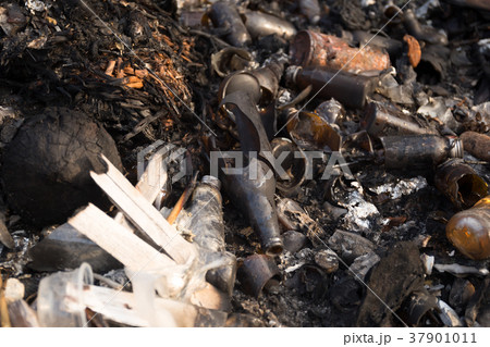 Broken glass bottles and garbage in burned trash Broken glass bottles and garbage in burned trash 37901011