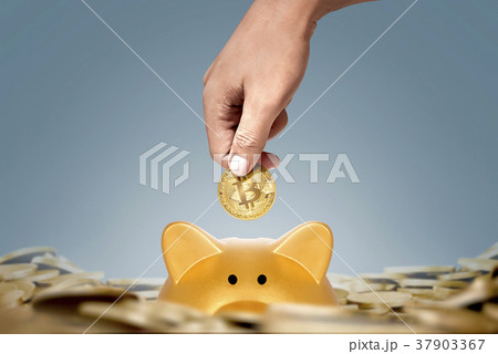 Man hands putting in golden bitcoin to piggy bank 37903367