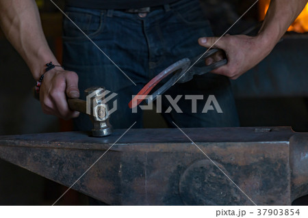 farrier making a traditional horseshoe on a forge farrier making a traditional horseshoe on a forge 37903854