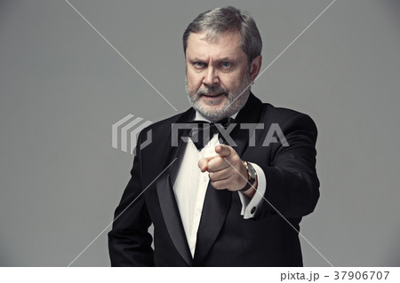 Senior Businessman standing and pointing to camera Senior Businessman standing and pointing to camera 37906707