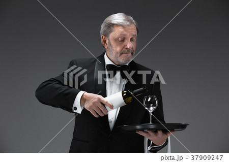 professional waiter in uniform is serving wine professional waiter in uniform is serving wine 37909247
