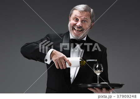 professional waiter in uniform is serving wine 37909248