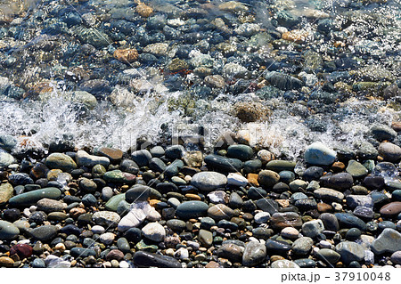 Sea surf with foam waves on rocky shore 37910048