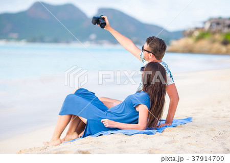 Happy couple taking a selfie photo on white beach Happy couple taking a selfie photo on white beach 37914700