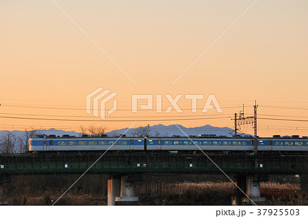夕焼けの奥多摩と秩父の山を背景に多摩川を渡る中央線189系臨時特急電車 夕焼けの奥多摩と秩父の山を背景に多摩川を渡る中央線189系臨時特急電車 37925503
