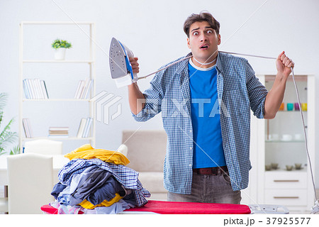 Young man husband doing clothing ironing at home 37925577
