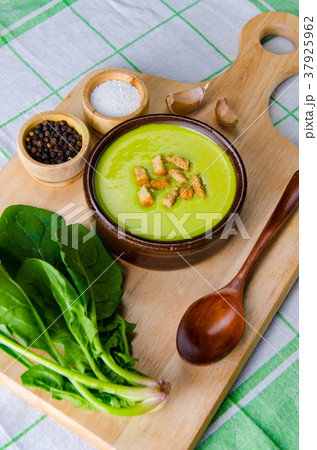 Spinach soup served on wooden board  37925962