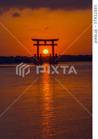 弁天島の鳥居に入る夕日の写真素材