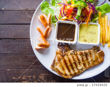 Grilled pork chop steak, French fries and salad Grilled pork chop steak, French fries and salad 37939420