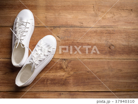 Couple of white shoe on wood background Couple of white shoe on wood background 37940310