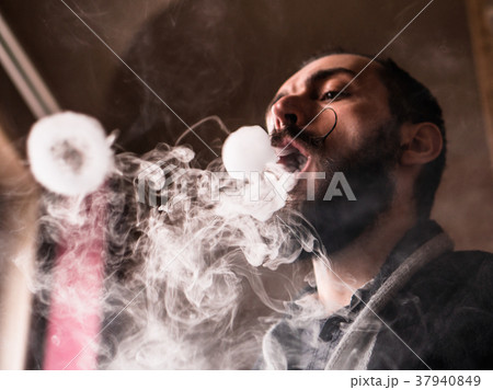 Man with Beard and Mustages Vaping an Electronic 37940849