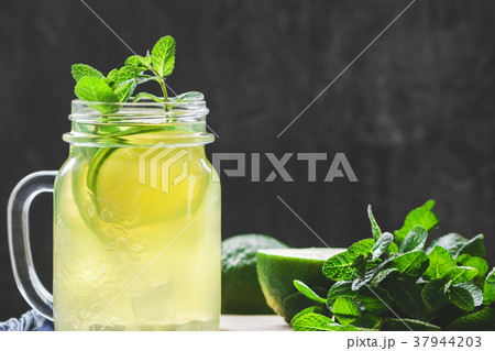 Lemonade mojito in a glass jar with lime and mint Lemonade mojito in a glass jar with lime and mint 37944203
