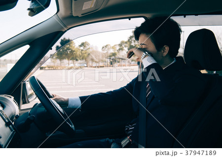 運転中に疲れを感じるビジネスマン 37947189