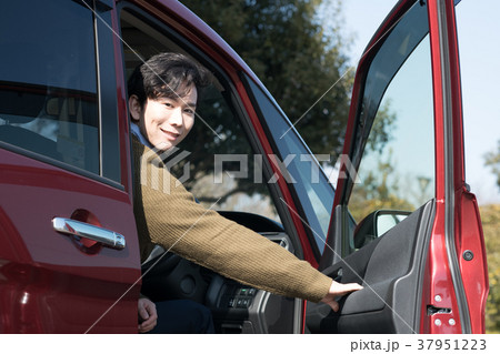 車に乗り込む若い男性の写真素材