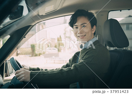 車を運転する若い男性 笑顔の写真素材