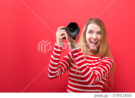Young woman holding a camera Young woman holding a camera 37951850