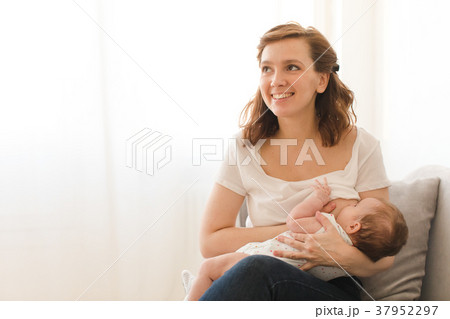 Cheerful woman breastfeeding child Cheerful woman breastfeeding child 37952297