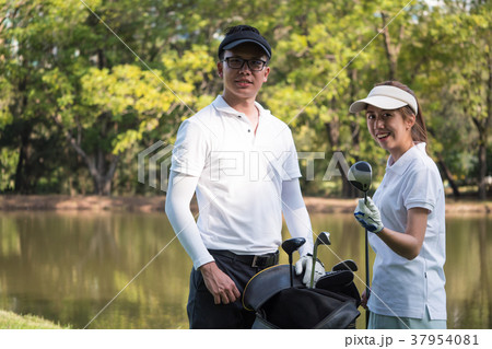 Asian young couple playing golf on golf course Asian young couple playing golf on golf course 37954081