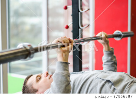 Young male patient doing bench press exercise at Young male patient doing bench press exercise at 37956597