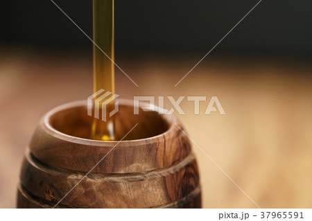 organic honey pour into wooden pot 37965591