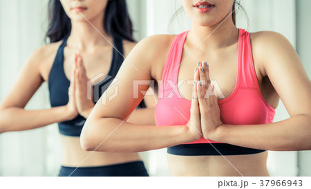 Women practicing yoga pose in fitness gym class Women practicing yoga pose in fitness gym class 37966943