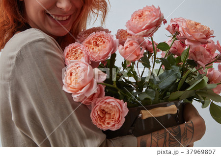Woman holding a vase with fresh pink roses Woman holding a vase with fresh pink roses 37969807