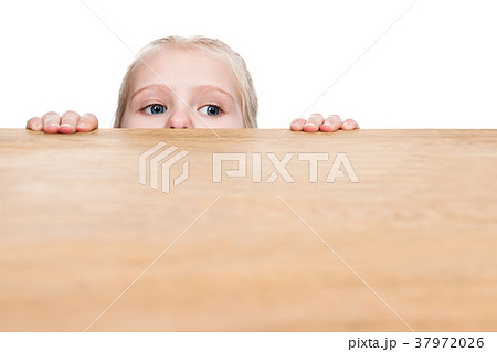 Child looks out from under the table Child looks out from under the table 37972026