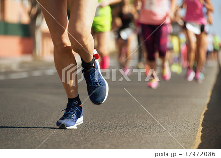 Marathon runners running on city road 37972086
