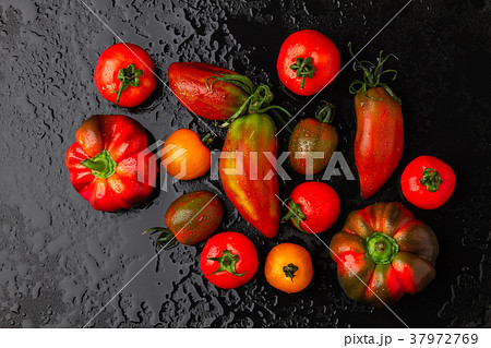 Fresh tomatoes and peppers on a black background Fresh tomatoes and peppers on a black background 37972769