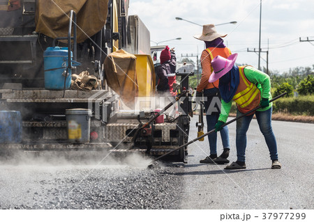 Worker operating the process of building new asphalt road on the new road construction site in Thailand 37977299