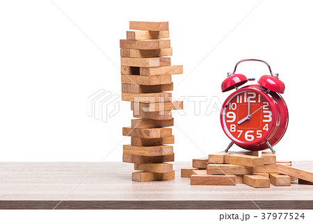 Pile of blocks wood game and red alarm clock on wooden table. Studio shot and isolated on white Pile of blocks wood game and red alarm clock on wooden table. Studio shot and isolated on white 37977524
